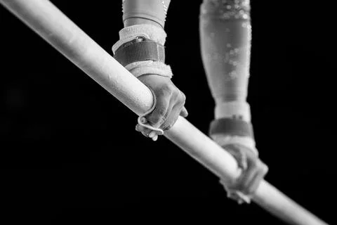Someone on the parallel bars in a gymnastics competition with their hands claspe Stock Photos
