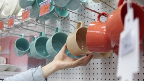 Someone picks a big ceramic cup in the supermarket. Vídeos de archivo 99044535