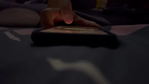 Someone is playing with a smartphone at night Stock Footage 325650511