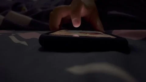 Someone is playing with a smartphone at night Stock Footage 325650513