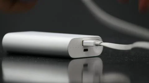 Someone plugging cable to the usb power bank. Fotos de archivo