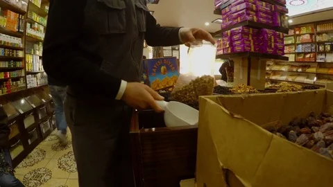 Someone pours nuts into a package in a spice store Stock Footage 82281167