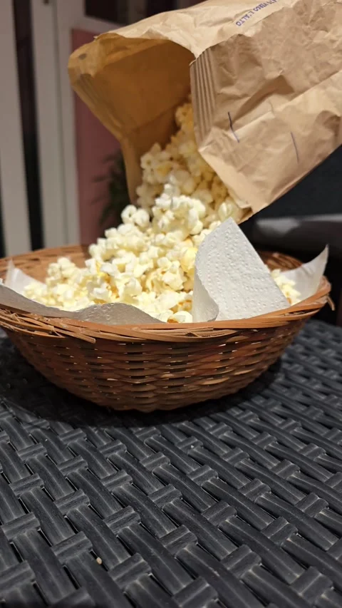 Someone pours popcorn into the basket to make a snack Stock Footage 307220429