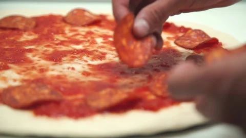 Someone is preparing meat pizza in the kitchen. Stock Footage 131597876