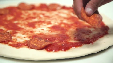 Someone is preparing meat pizza in the kitchen. Stock Footage 132559373