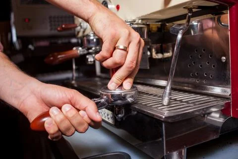 Someone is prepering grind coffe beans to make coffee in coffee machine. Clos Stock Photos