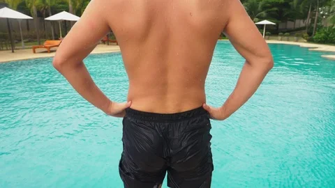 Someone pushed the young man into the pool, he ridiculously falls and makes a Stock Footage 98515198