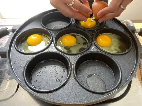 Someone put scrambled eggs or sunny side up on teflon egg or omelette pan Stock Photos