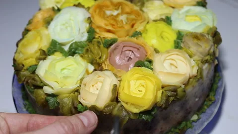 Someone puts a flower on the cake. Imitations of handmade roses and Ranunculus. Stock Footage 143675445