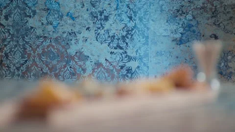 Someone puts the plate next to the board with crackers cheese nuts and olives Stock Footage 131422560