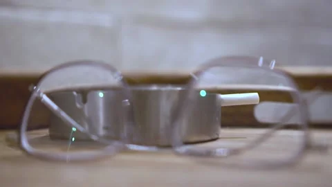 Someone Putting Down Her His Cigarette And Glasses To The Table Stock Footage 131655455