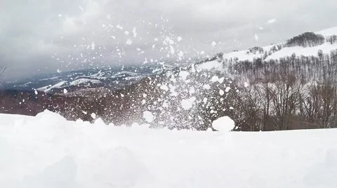Someone Rolls the Snow Clumps From Mountainside Stock Footage 60603910