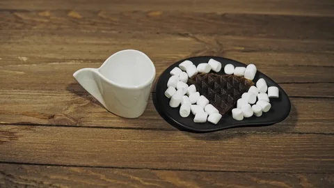 Someone sets the table for Breakfast, coffee and waffles with marshmallows. Stock Footage 100190304