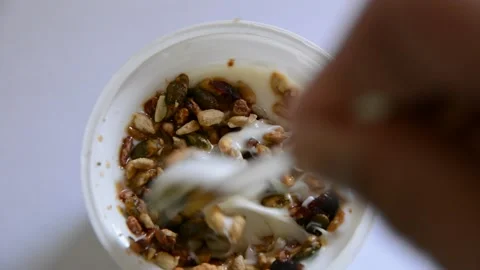 Someone stirs yogurt with seeds Видео 130371953
