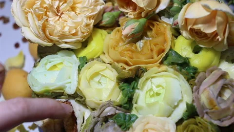 Someone takes a bite of cake. Baked goods are decorated with imitation flowers o Stock Footage 143675904