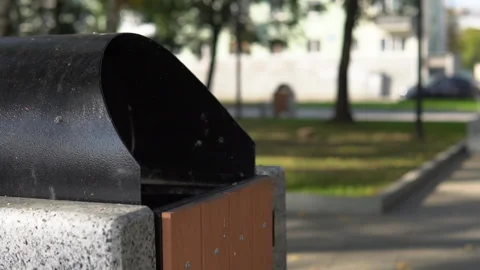 Someone throws garbage in the urn on the street. Stock Footage 95538469