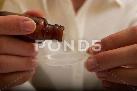Someone throws a liquid medicine on a spoon Stock Photos