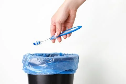 Someone throws a toothbrush in the trash. garbage sorting Stock Photos