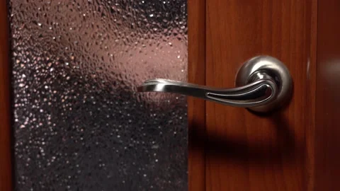Someone is Trying to Enter the Room. The Door Handle Twitches Several Times Stock Footage 149670296