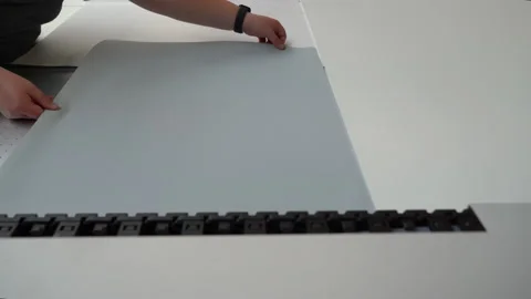 Someone turning over a sheet of paper on a large format flatbed printer Stock Footage 224961654
