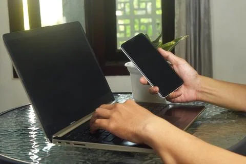 Someone is using mobile banking and a laptop Stock Photos