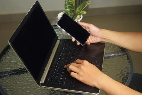Someone is using mobile banking and a laptop Stock Photos