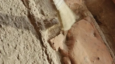 Someone using a small paint brush to clean dust and sand from the gaps of a.. Stock Footage 324821579