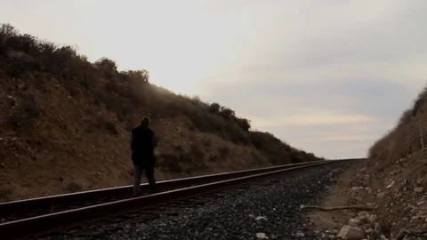 Someone walking away on trains tracks Stock Footage 83136655