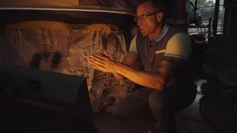 Someone warms his hands at the mobile air heater, which dries the car after Stock Footage 93133668