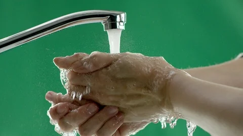 Someone washes his hands under the tap, green background Stock Footage 111534228