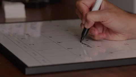 Someone Writes Notes on a White Board Calendar with a Marker Stock Footage 270291524