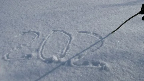 Someone writes with a stick in the snow 2022. Stock Footage 163992176