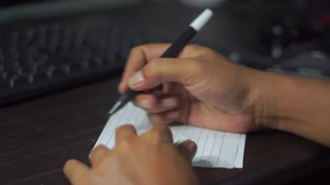 Someone is writing small notes on scrap paper Stock Footage 205533996