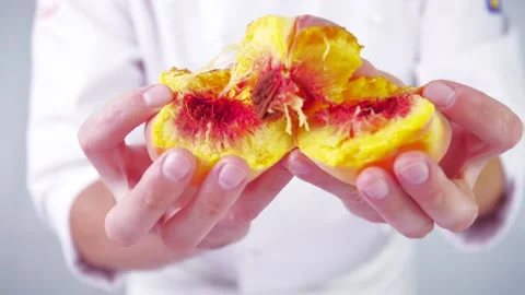 Someone's breaking a peach in half in slow motion. Stock Footage 141523007