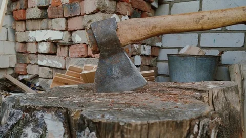 Someone's hands are sticking an axe into a big stump. Stock Footage 115598092