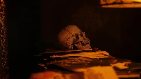 Someone's hands are taking a human skull from a pile of manuscripts. Stock Footage 118188443
