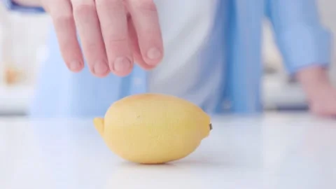 Someone's spinning a whole lemon on the table Stock Footage 130991036