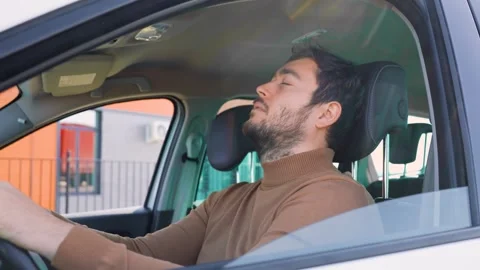 Something very upset young man behind the wheel of a car lay down to rest. Stock Footage 271310562