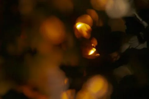 A somewhat blurry image depicts a candle being lit in the darkness Stock Photos