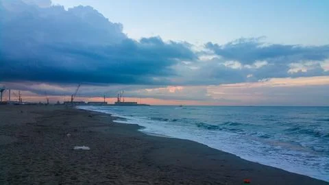 A somewhat blurry picture captures a cloudy sky looming over a serene lake,.. Stock Photos