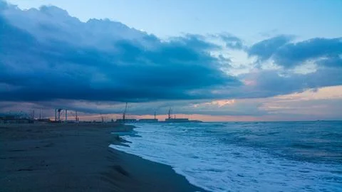 A somewhat blurry picture captures a cloudy sky looming over a serene lake,.. Stock Photos