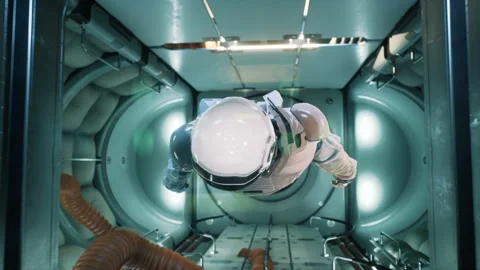 Somewhere in distant space, an astronaut hovers inside his spaceship. The Stock Footage 147393962
