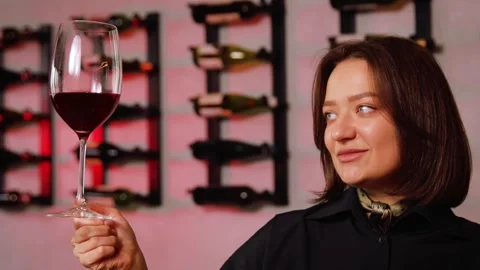 Sommelier hand holding red wine glass, tasting beverage in winery cellar Stock Footage 332231287