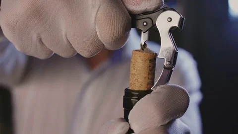 Sommelier at the restaurant opens a bottle of red wine Stock Footage 82472714