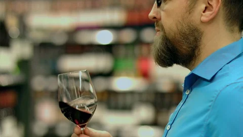 A sommelier tastes red wine at the request of client 스톡 동영상 93736317