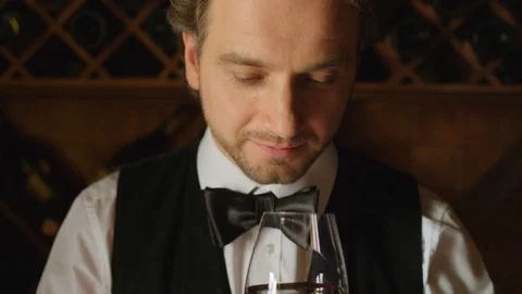 Sommelier is tasting red wine on wood background. Close up. Slow motion Stock Footage