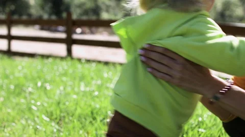 Son of 2 year old runs to meet his mother and jumps into her arms Stock Footage 127764354