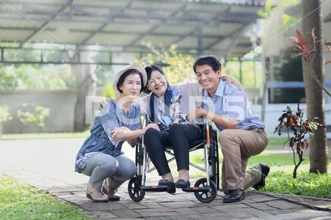Son and daughter in law looking after elderly mother in backyard Stock Photos