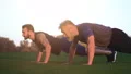 The son and a father pushing up on the grass 4k or 4k+ Resolution
