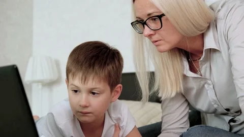 Son and mother do homework online at home. Mother teaches the child. Isolation Stock Footage 140759200